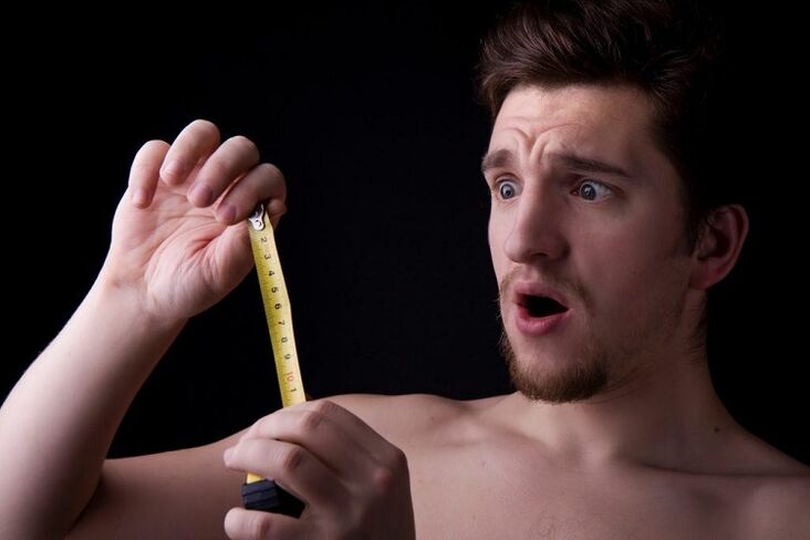 a man with a tape measure measuring his penis before enlargement surgery